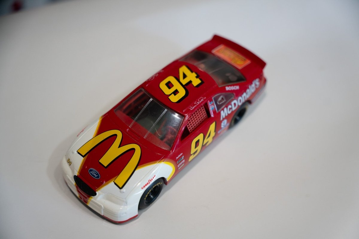 Racing Champions 1/64 scale diecast NASCAR Ford Thunderbird number 94 McDonalds livery from 1995, shown from above displaying the car's red and yellow paint scheme