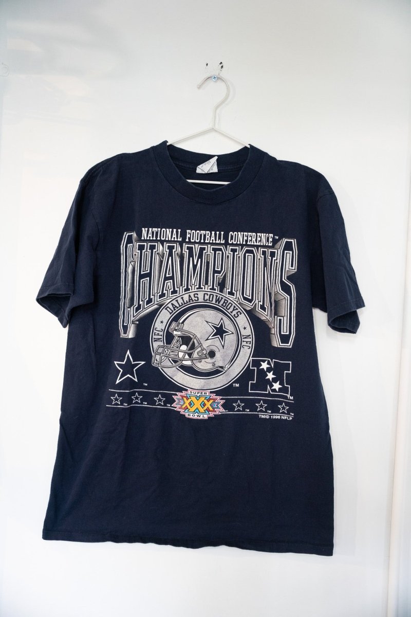 Navy blue 1996 Dallas Cowboys NFC Champions shirt with silver CHAMPIONS lettering, Cowboys helmet badge, and Super Bowl XXX logo