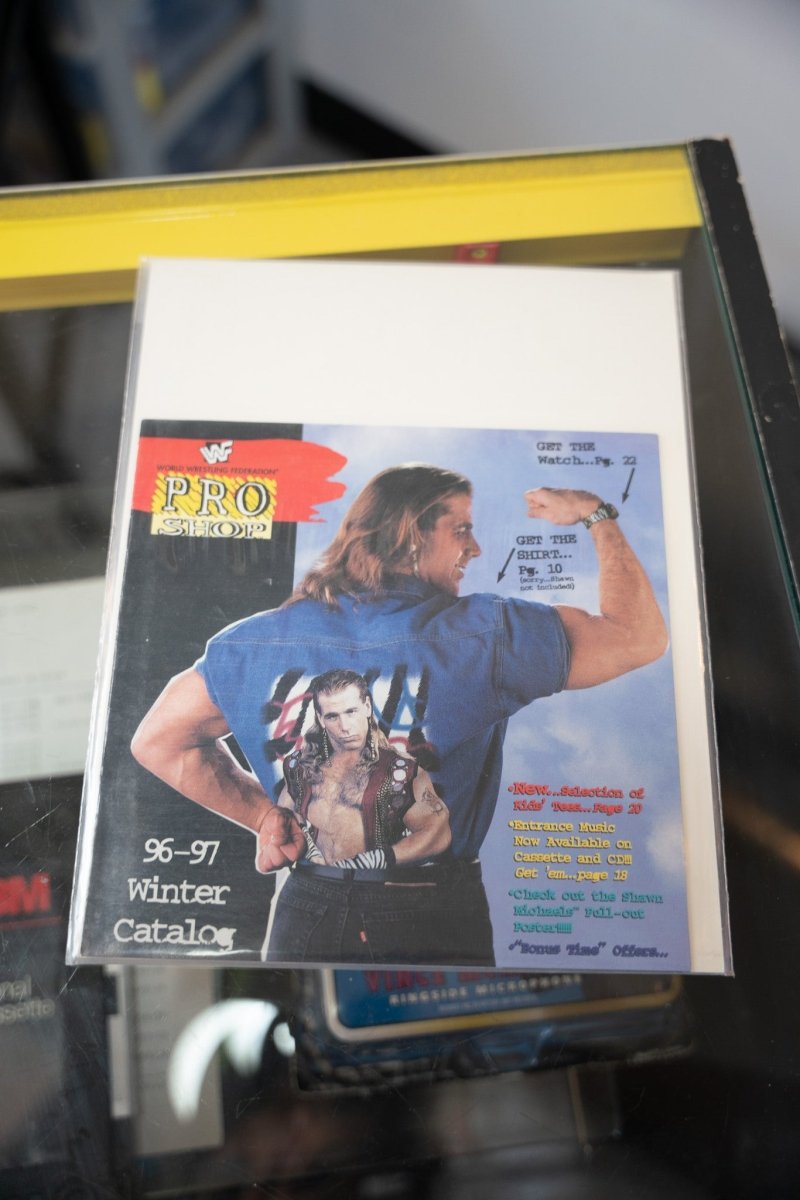 1997 WWF Pro Shop 96-97 Winter Catalog Shawn Michaels cover blue tee flexing HBK inset photo merchandise callouts WWF logo