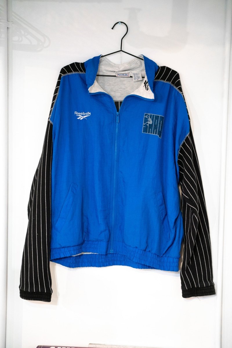 Royal blue 90s Reebok Shaq windbreaker jacket black white pinstripe sleeves SHAQ dunk logo Reebok logo full-zip gray collar size XL