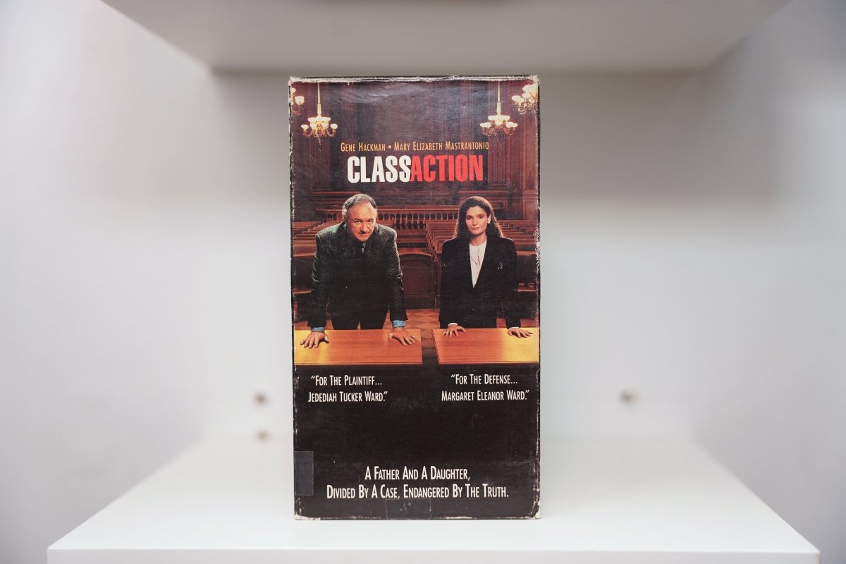 Class Action VHS cover with Gene Hackman and Mary Elizabeth Mastrantonio standing at courtroom table with chandeliers behind them