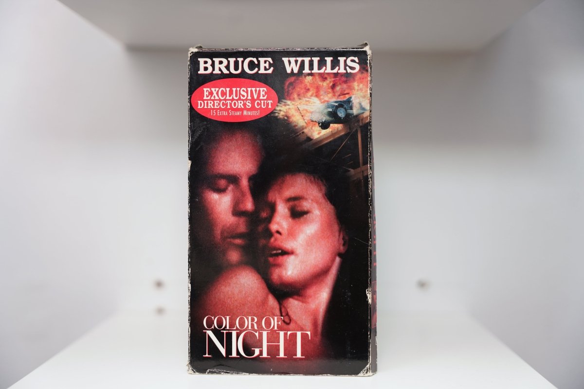 Color of Night VHS cover with Bruce Willis name, Exclusive Director's Cut badge, intimate red-toned embrace and explosion scene