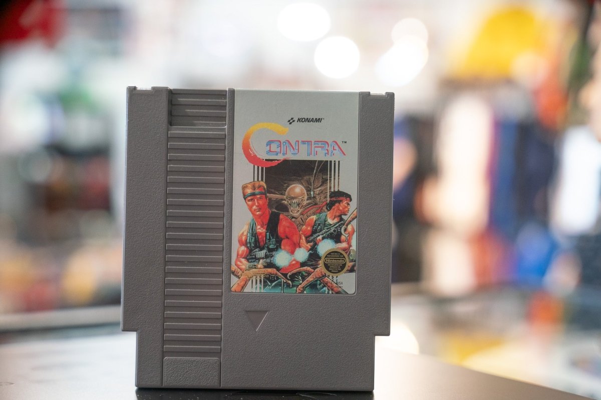 Konami Contra Nintendo NES cartridge from 1988, showing black plastic game case with red and yellow label artwork featuring action game imagery