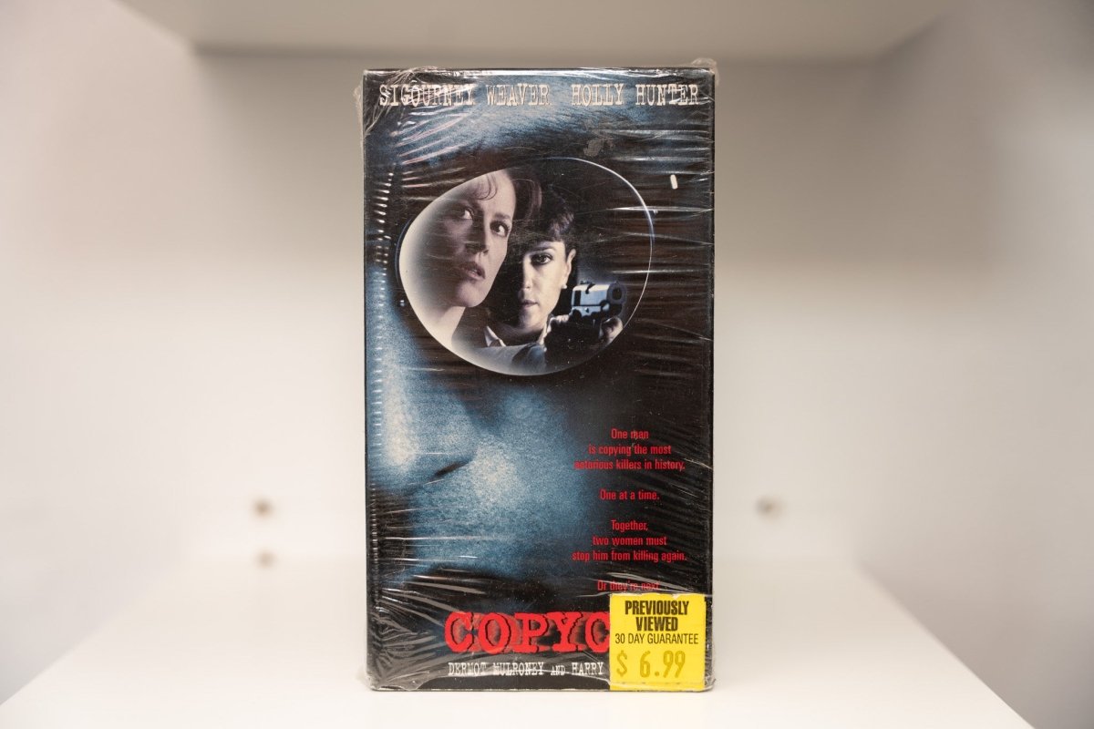 Copycat VHS cover with Sigourney Weaver reflection and Holly Hunter in scope holding gun, dark moody design, Previously Viewed sticker