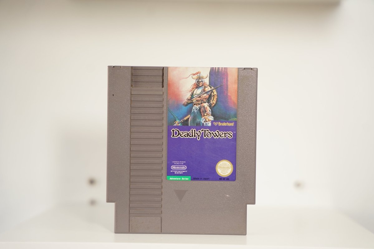 NES Deadly Towers gray cartridge warrior horned helmet sword purple mountains towers Broderbund Deadly Towers text Nintendo Adventure Series Seal