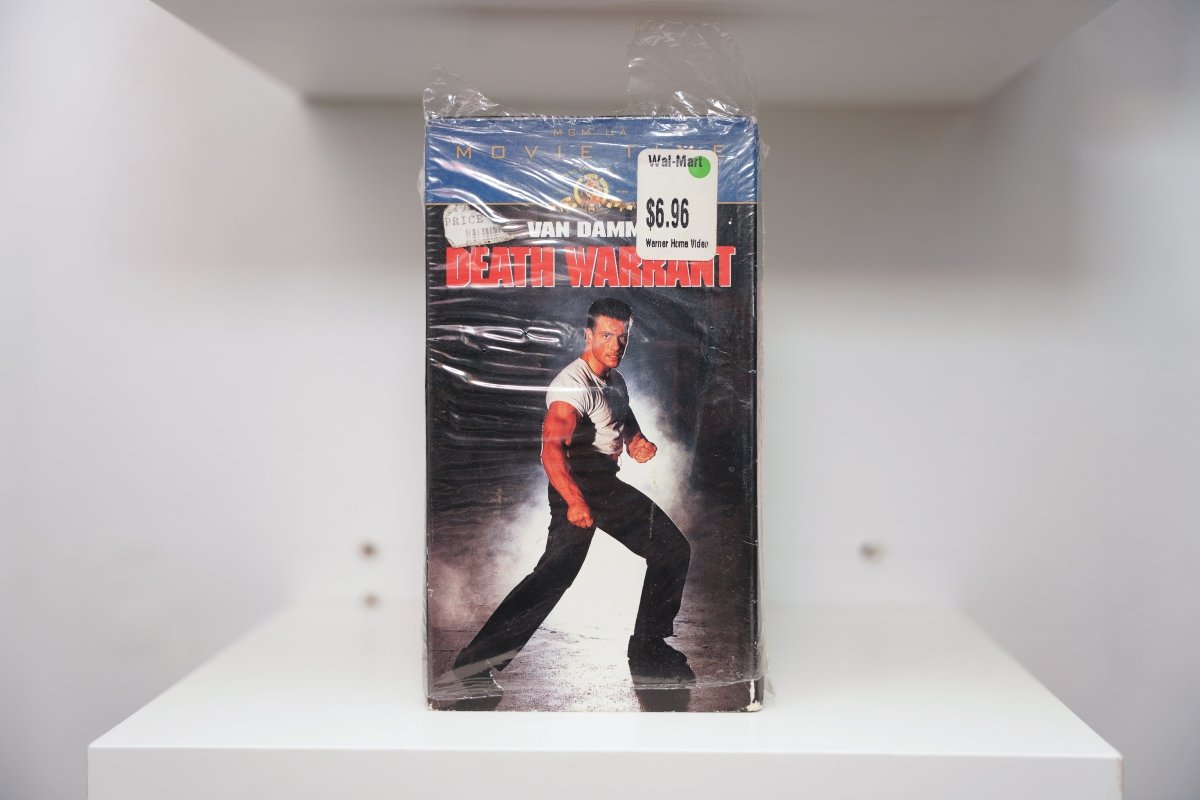 Death Warrant VHS with Jean-Claude Van Damme in fighting stance, MGM/UA Movie Time banner, sealed with Wal-Mart $6.96 price sticker