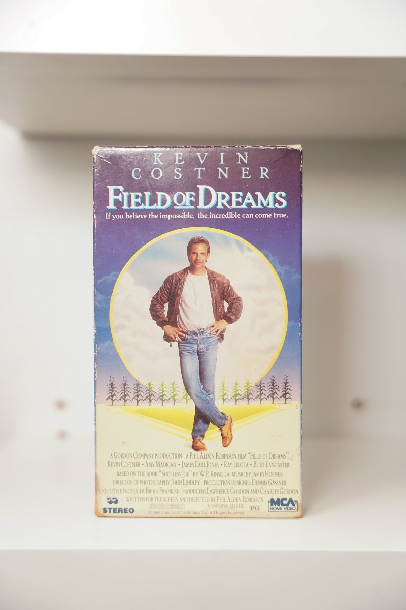VHS Field of Dreams Kevin Costner golden light leather jacket cornfield purple sky KEVIN COSTNER FIELD OF DREAMS text believe impossible tagline MCA PG