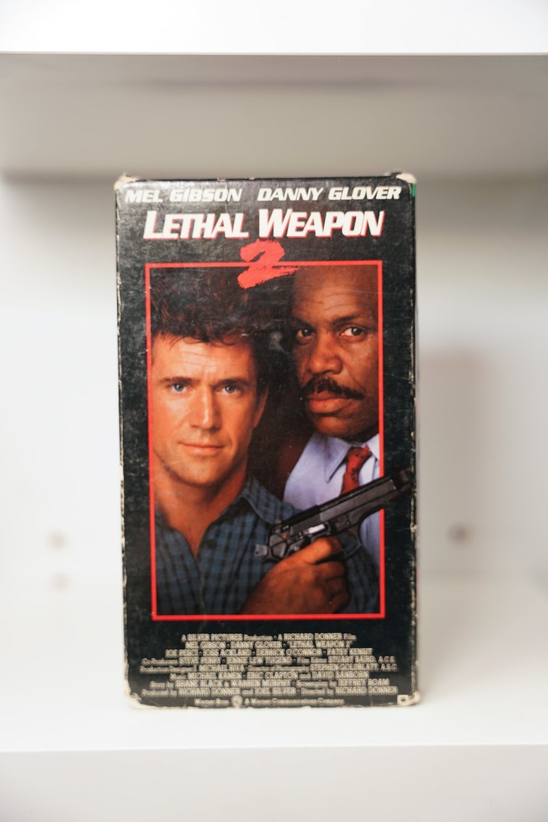 Lethal Weapon 2 VHS cover with Mel Gibson and Danny Glover in red-bordered photo, Glover holding gun, white title text with red 2