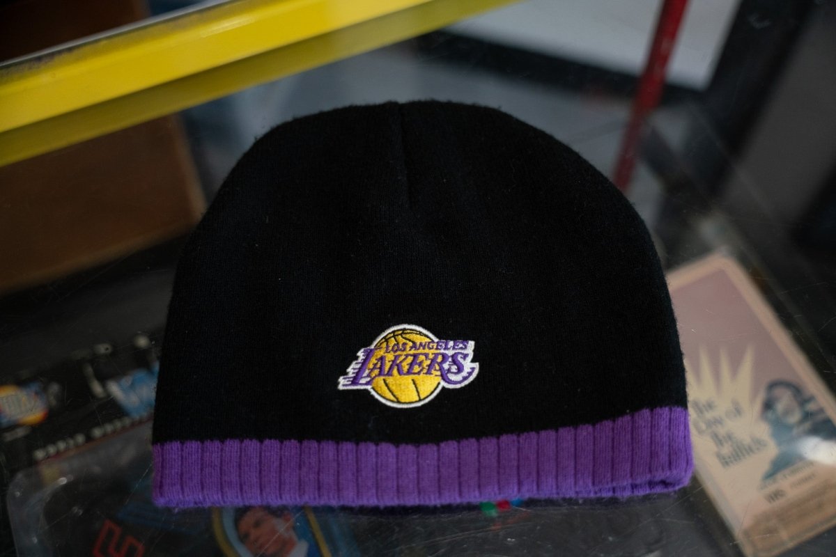 Black Los Angeles Lakers knit beanie with embroidered gold basketball Lakers logo and purple ribbed band at bottom