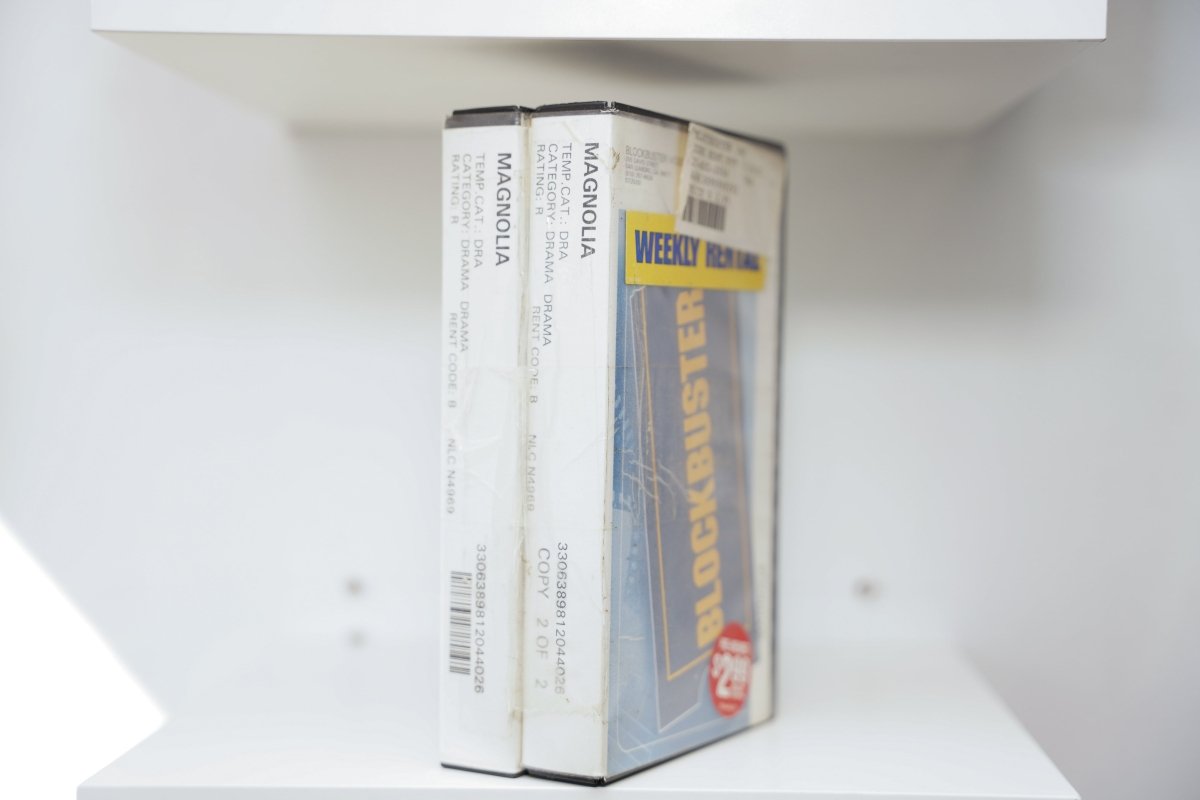 VHS Magnolia two tapes Blockbuster rental cases white spines MAGNOLIA Drama Rating R Blockbuster blue yellow branding Weekly sticker