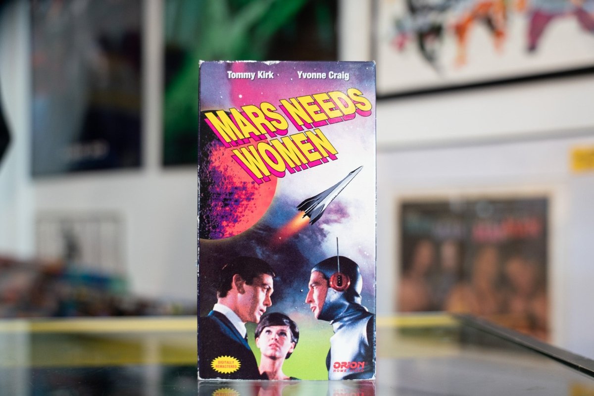 Mars Needs Women VHS tape with artwork showing retro sci-fi imagery and bold text on the front cover from the 1960s era