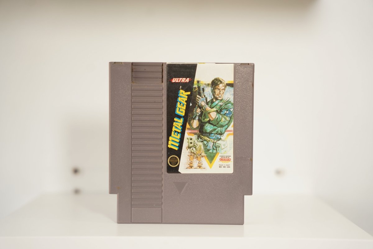 NES Metal Gear gray cartridge soldier Solid Snake green fatigues weapons yellow triangle robots ULTRA logo METAL GEAR metallic text Nintendo