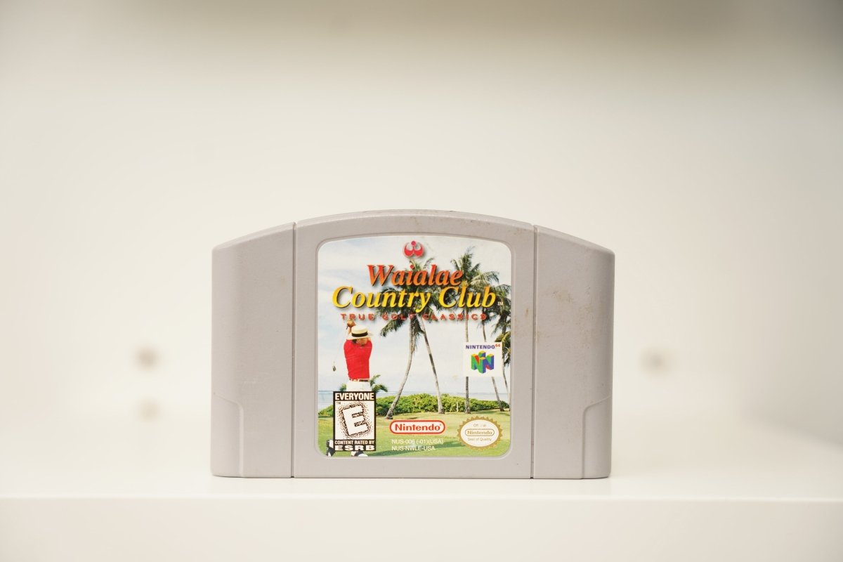 N64 Waialae Country Club True Golf Classics grey cartridge with golfer on Hawaiian course with palm trees, Nintendo logo, Everyone rating