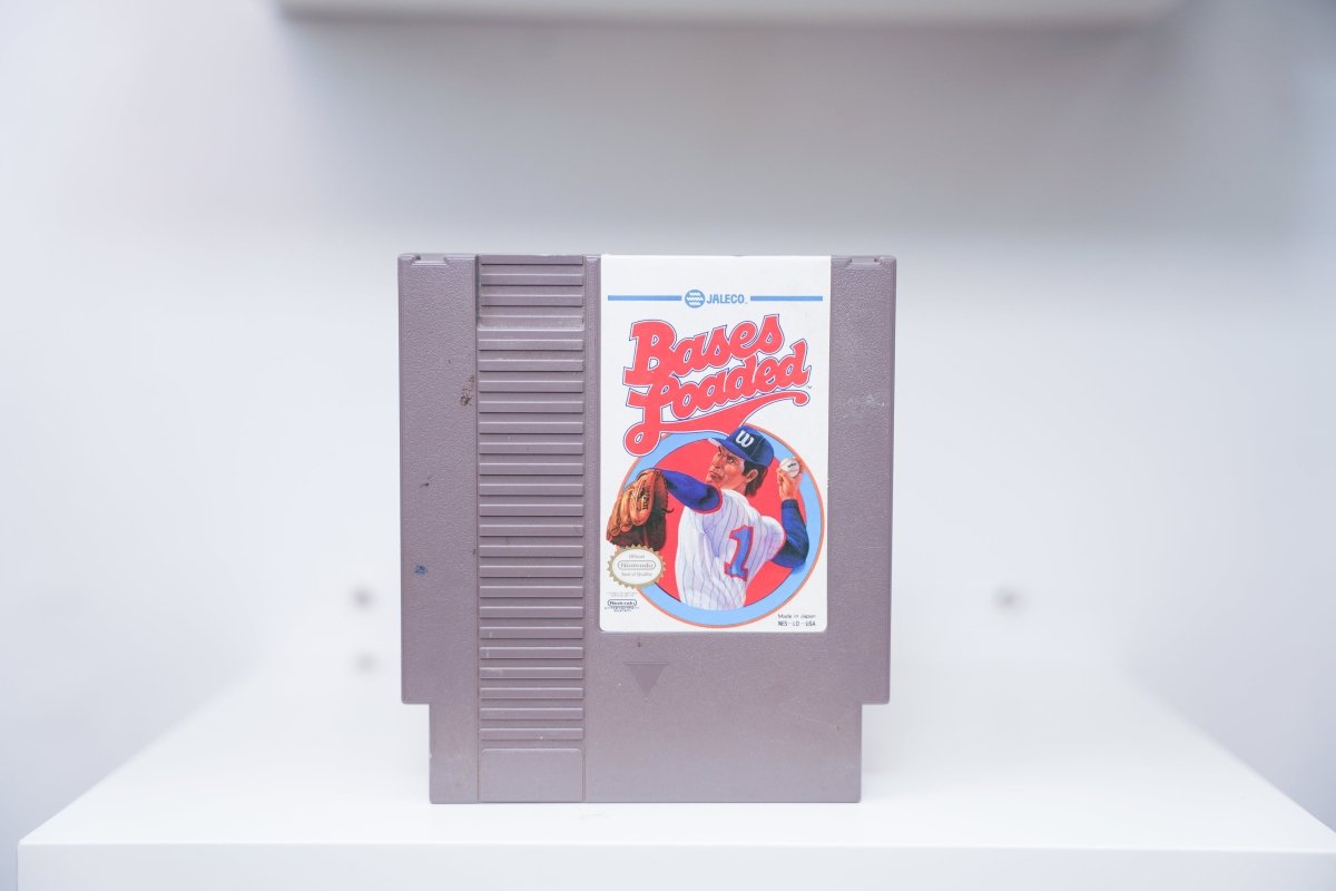 NES Bases Loaded grey cartridge with painted pitcher in blue pinstripe uniform in red circular frame, Jaleco logo