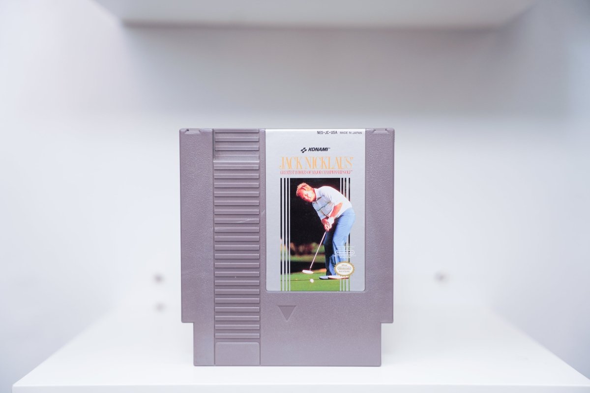 NES Jack Nicklaus Greatest 18 Holes grey cartridge with photo of Nicklaus mid-swing on golf course, Konami logo, Made in Japan