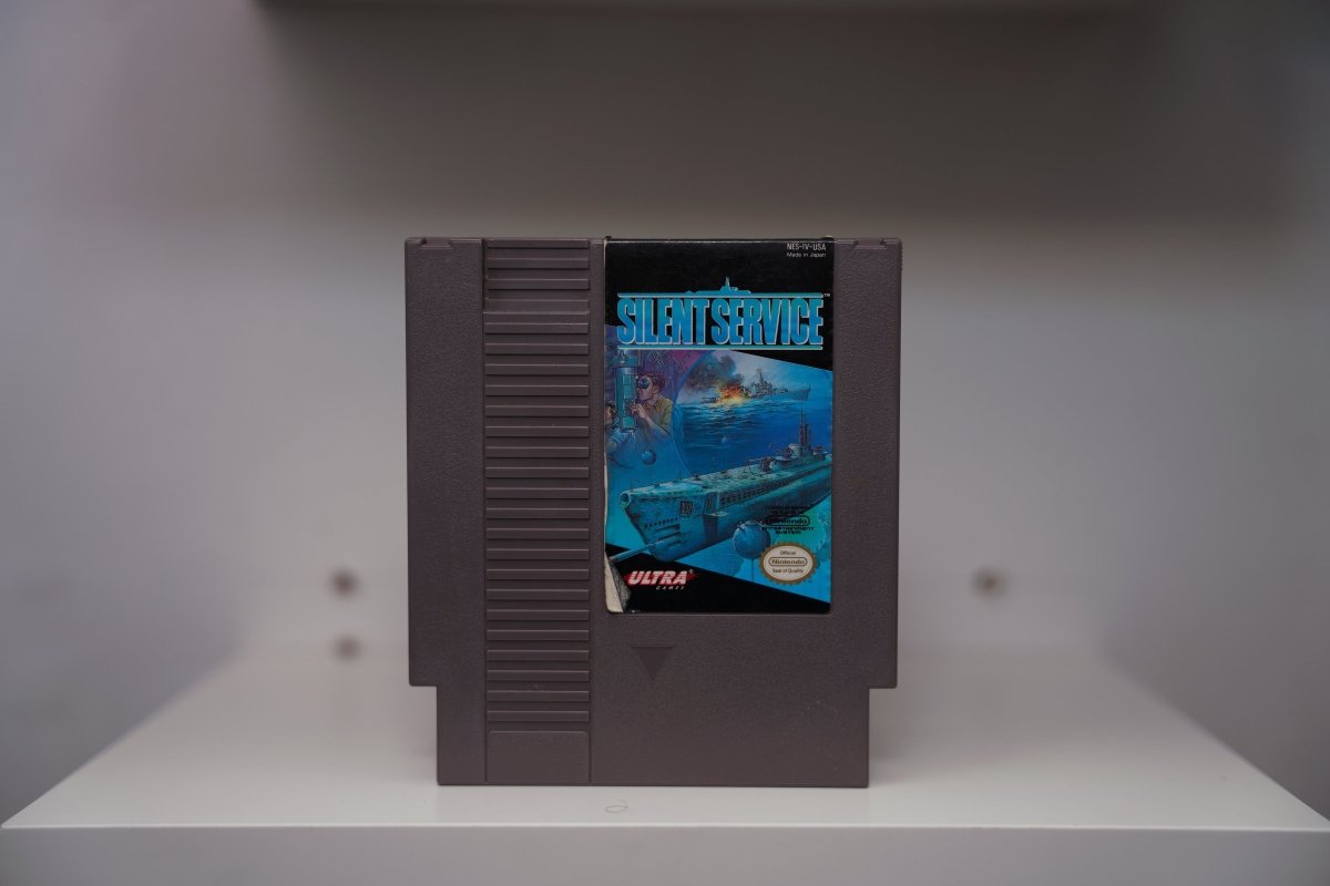 NES Silent Service grey cartridge with submarine warfare artwork showing surfacing sub, captain with binoculars, burning ship, Ultra Games logo