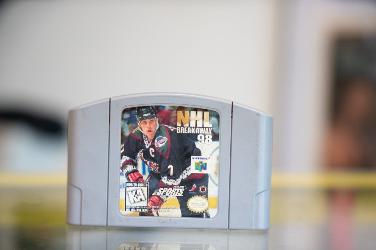Nintendo NHL Breakaway 98 video game cartridge for N64, featuring hockey player artwork and blue/orange color scheme on packaging from 1997