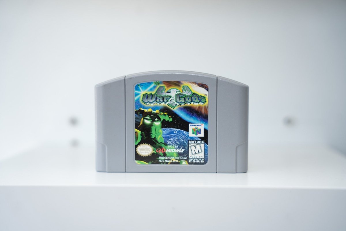 Nintendo 64 War Gods gray N64 cartridge green stone warrior cosmic space background War Gods silver green text Midway Mature rating