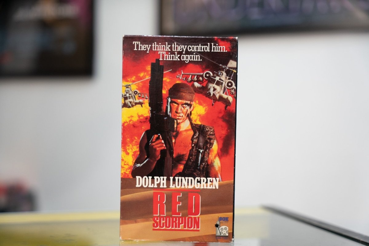 Red Scorpion VHS fiery orange red sleeve with Dolph Lundgren in military gear holding gun helicopters explosions and red metallic RED SCORPION title