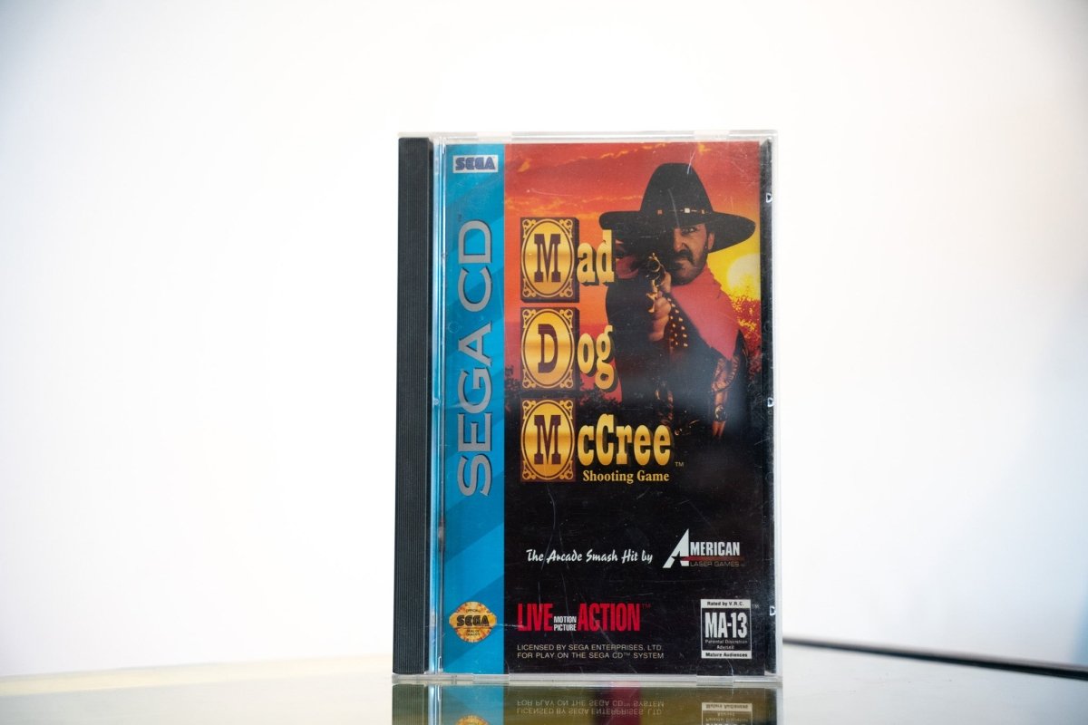 Sega CD Mad Dog McCree game complete in tall case blue spine outlaw black hat revolver sunset Mad Dog McCree Western text American Laser Games MA-13