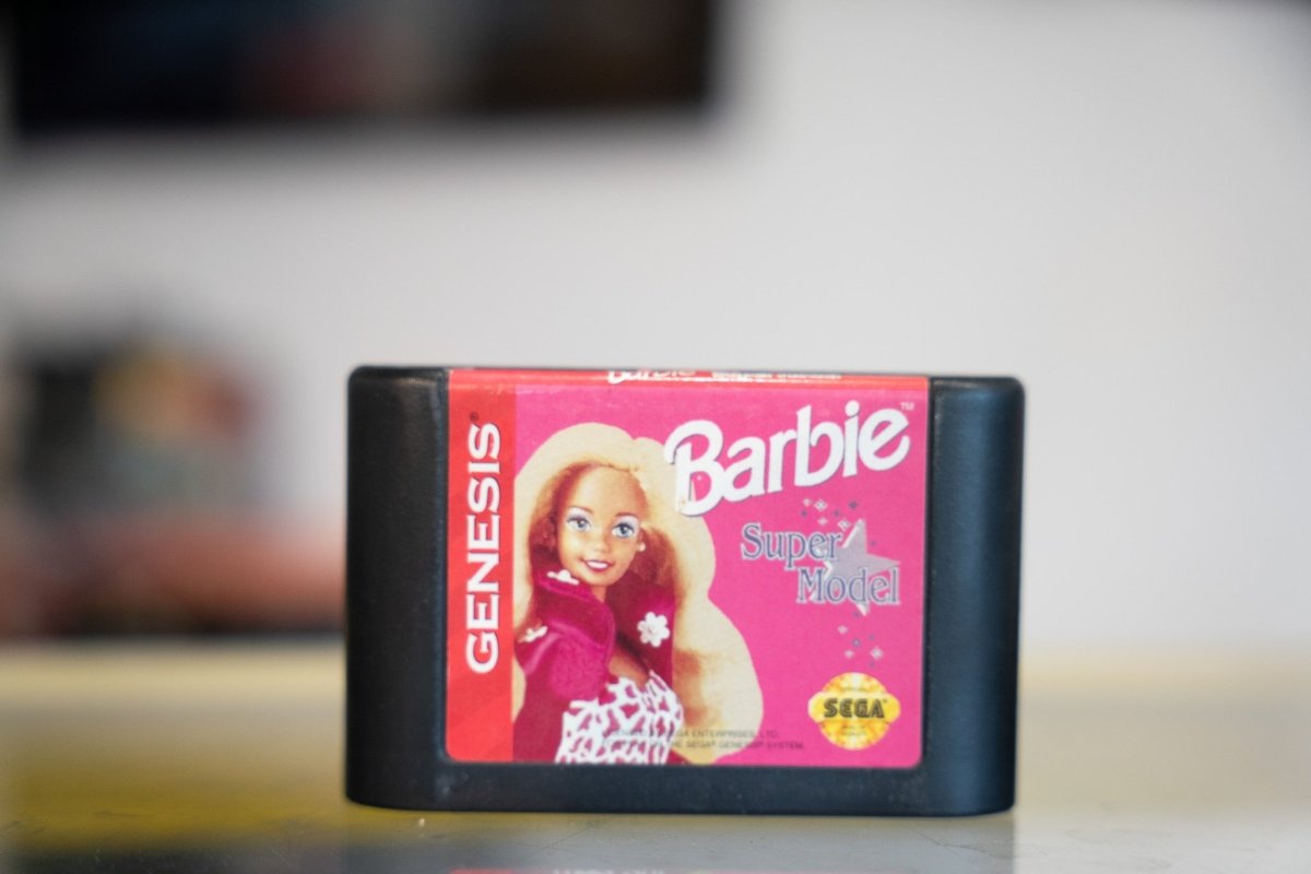 Sega Genesis Barbie Super Model black cartridge with hot pink label Barbie in floral dress pink script logo and Sega branding