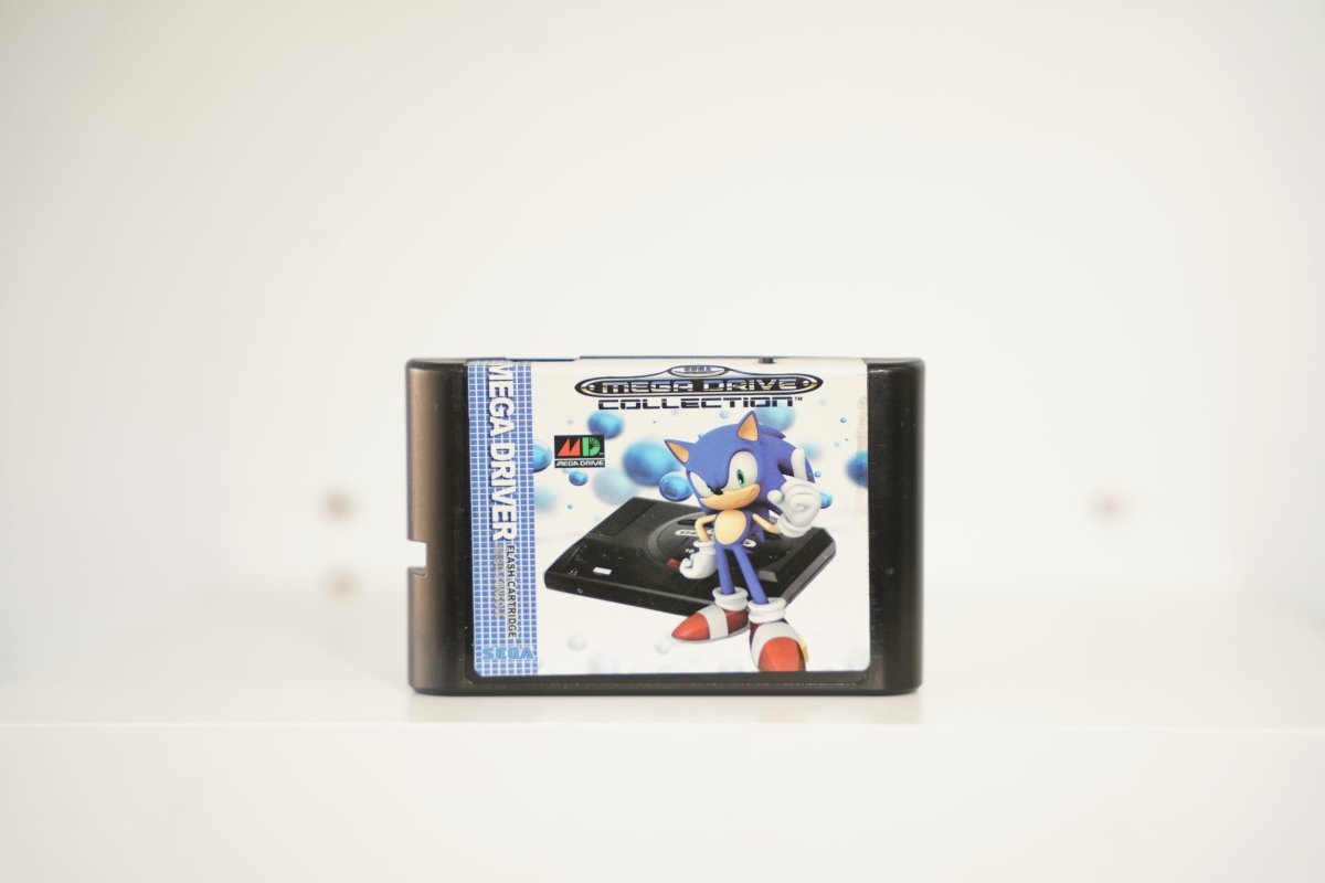 Sega Genesis Mega Drive Collection black cartridge Sonic Hedgehog standing on Mega Drive console MEGA DRIVE COLLECTION text MD logo Sega blue background