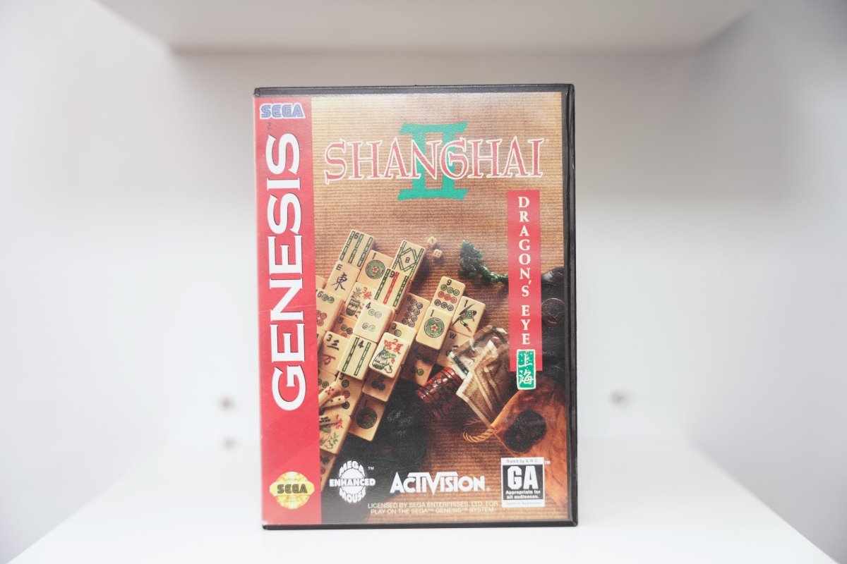 Sega Genesis Shanghai II Dragon's Eye case with Mahjong tiles on wooden surface, teal title text, Activision logo, Chinese seal stamp