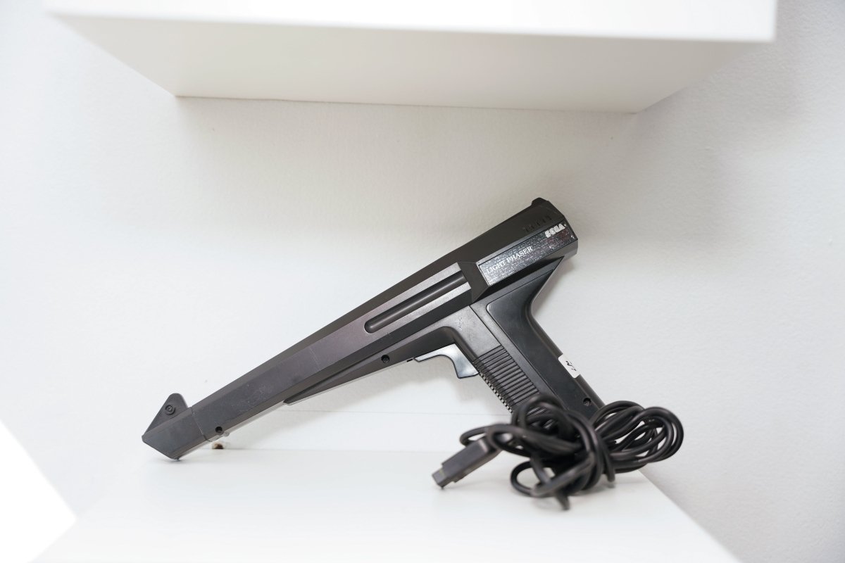 Sega Master System Light Phaser black light gun controller with angular futuristic design, Sega logo, wired cable