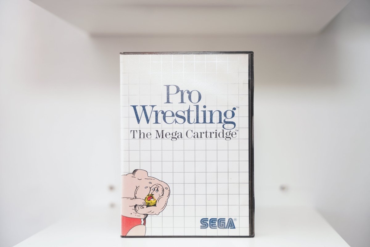 Sega Master System Pro Wrestling clamshell case with cartoon bald wrestler in red trunks, The Mega Cartridge subtitle, white grid design