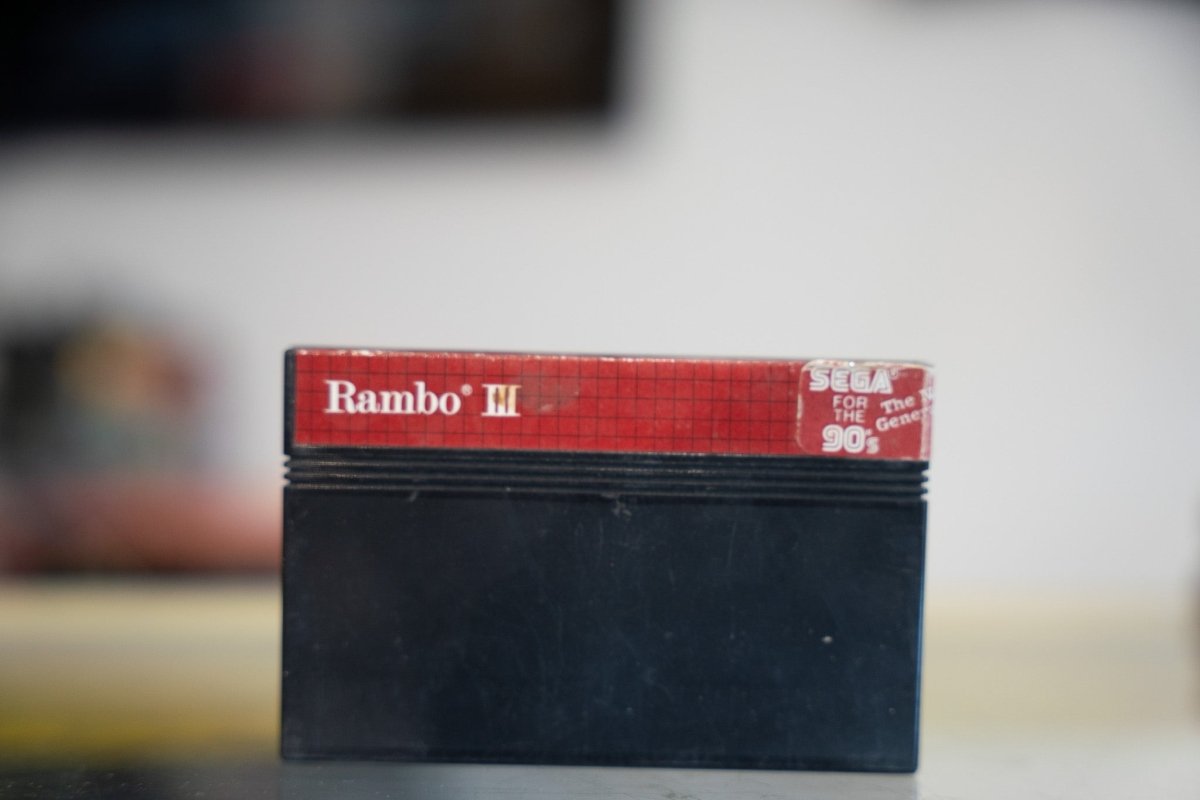 Sega Master System Rambo III black cartridge with red label strip gold Rambo III title and Sega For The 90s logo