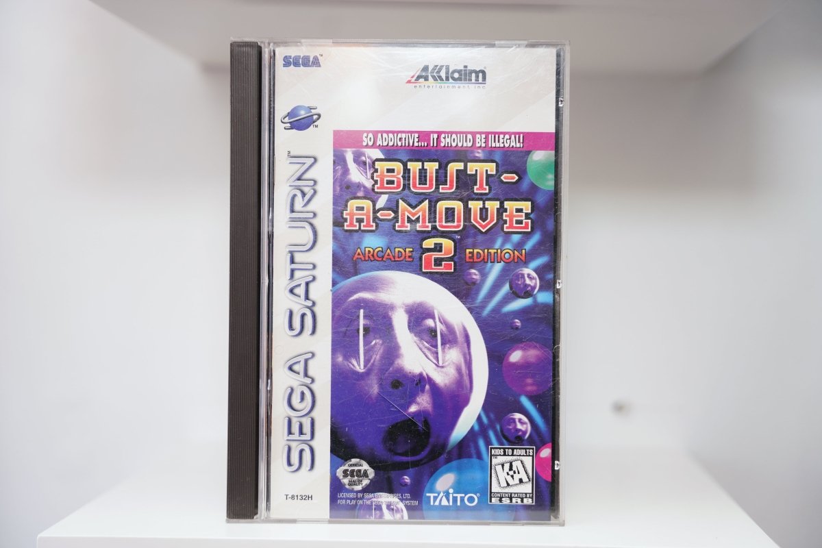 Sega Saturn Bust-A-Move 2 Arcade Edition jewel case with colorful bubbles, moon face, So Addictive tagline, Acclaim and Taito logos