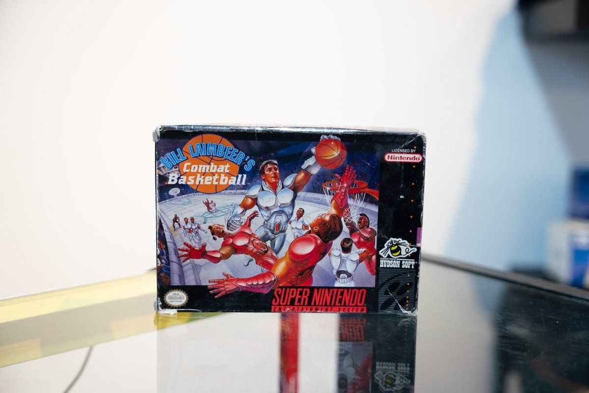 SNES Bill Laimbeer's Combat Basketball box with robotic players battling on futuristic court, Bill Laimbeer portrait, Hudson Soft bee logo