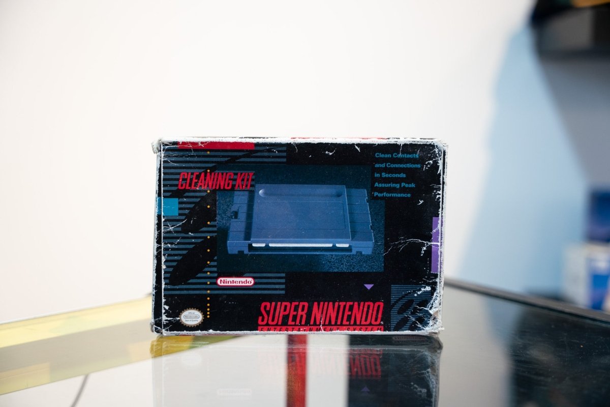 SNES Cleaning Kit box with Super Nintendo console photo, Clean Contacts and Connections text, Nintendo logo, dark design with red accents