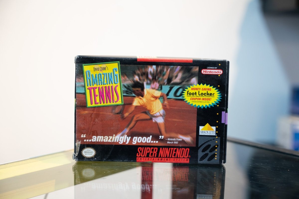 SNES David Crane's Amazing Tennis box with tennis player on clay court, Nintendo Power quote, Foot Locker coupon sticker, Absolute Entertainment