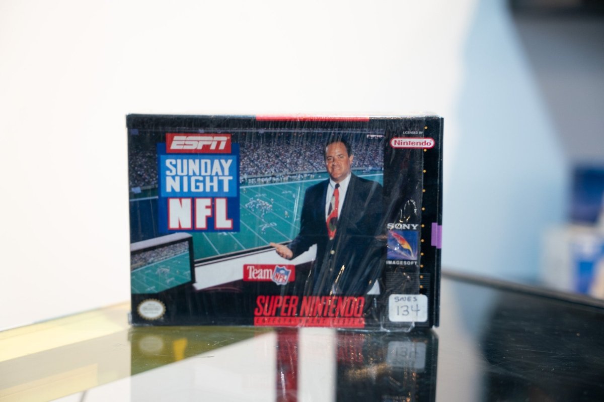 SNES ESPN Sunday Night NFL box with broadcaster at desk, stadium background, ESPN logo, Sony Imagesoft, appears sealed in shrink wrap