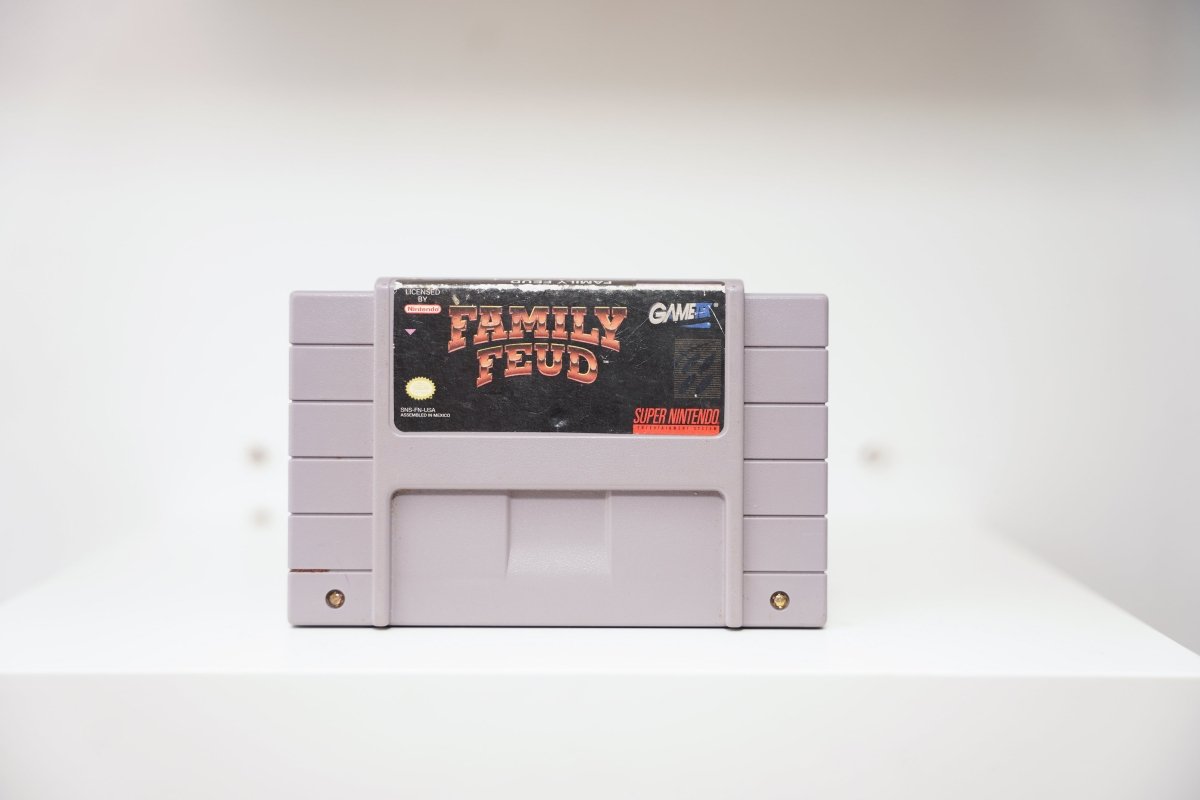 SNES Family Feud grey cartridge with red and gold Family Feud logo on dark background, GameTek logo, label wear