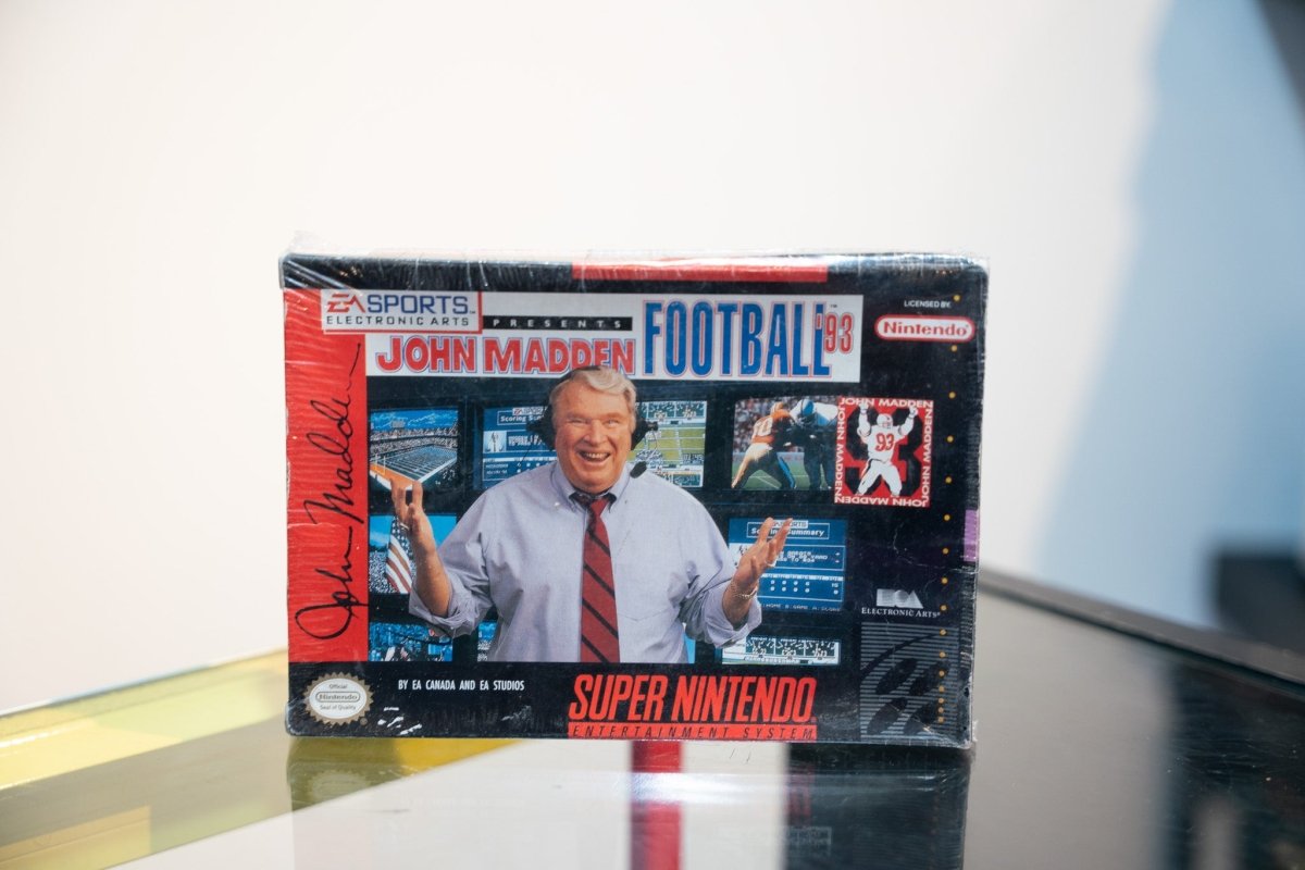 SNES John Madden Football 93 box with smiling John Madden in headset and tie, EA Sports Electronic Arts, appears sealed in shrink wrap