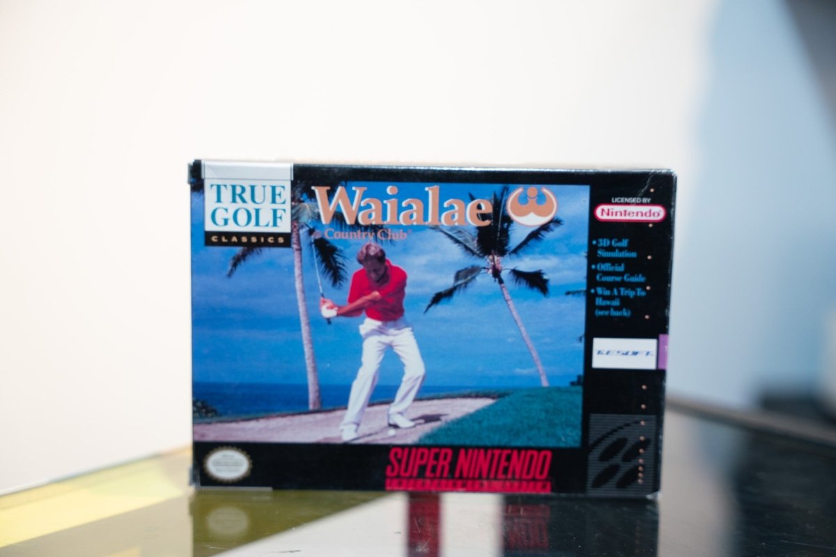SNES Waialae Country Club box with golfer swinging on Hawaiian course with palm trees and ocean, True Golf Classics logo