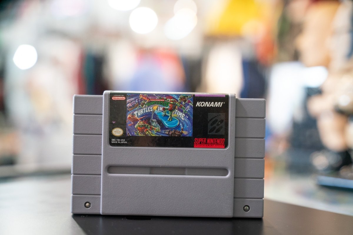 Nintendo Super NES Teenage Mutant Ninja Turtles Turtles In Time game cartridge, 1991, with black plastic casing and colorful front label artwork