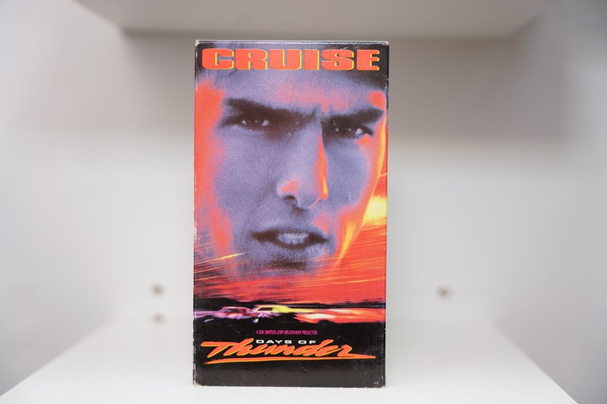 VHS Days of Thunder bold cover Tom Cruise close-up purple orange tones stock car racing CRUISE orange text DAYS OF Thunder script Paramount