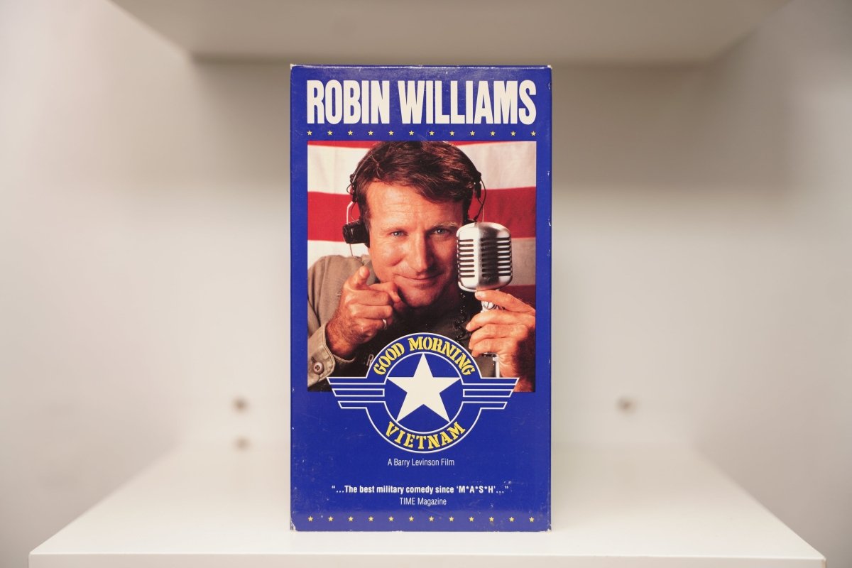 VHS Good Morning Vietnam blue cover ROBIN WILLIAMS white text headphones microphone pointing American flag military star emblem GOOD MORNING VIETNAM yellow text