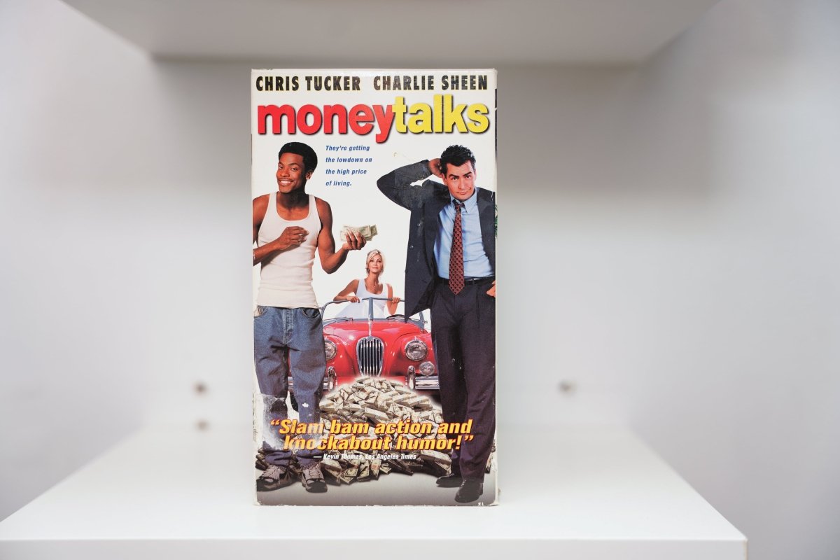 VHS Money Talks Chris Tucker white tank top cash Charlie Sheen suit red convertible moneytalks red yellow text Los Angeles Times