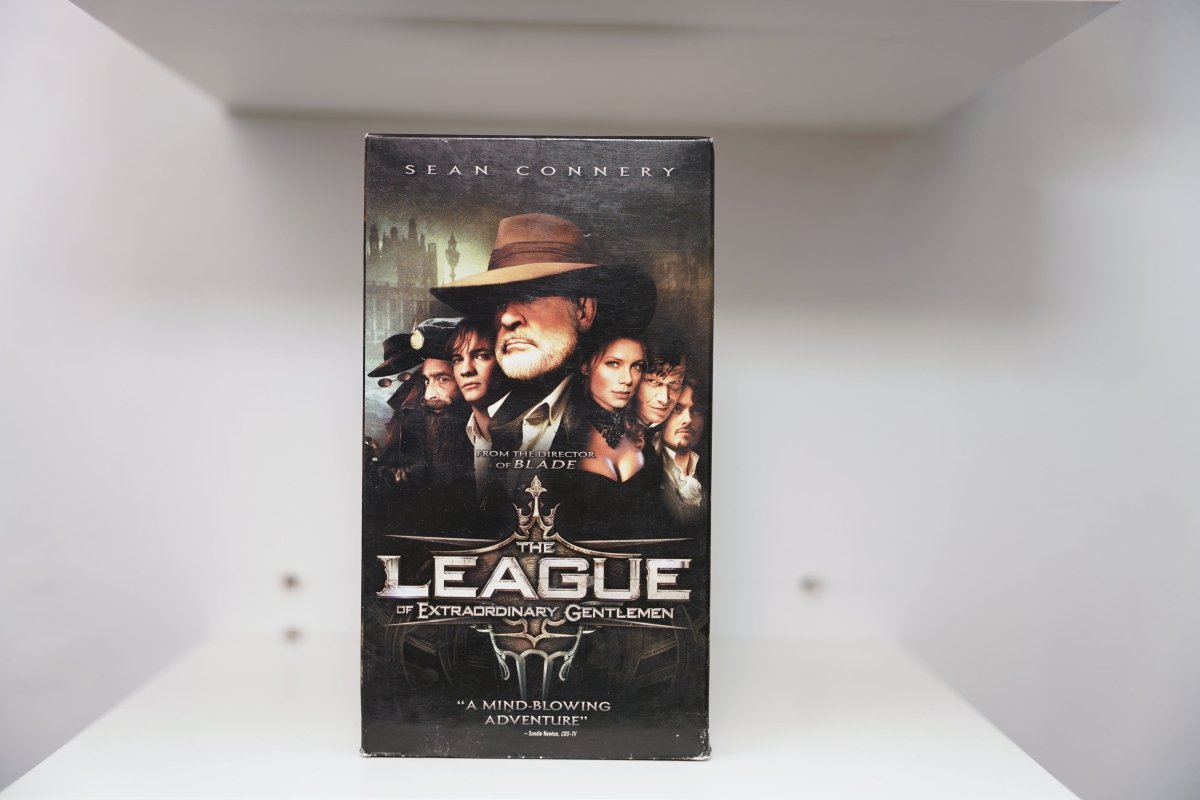 VHS League of Extraordinary Gentlemen dark cover Sean Connery fedora overcoat ensemble cast Victorian cityscape ornate LEAGUE silver gold text