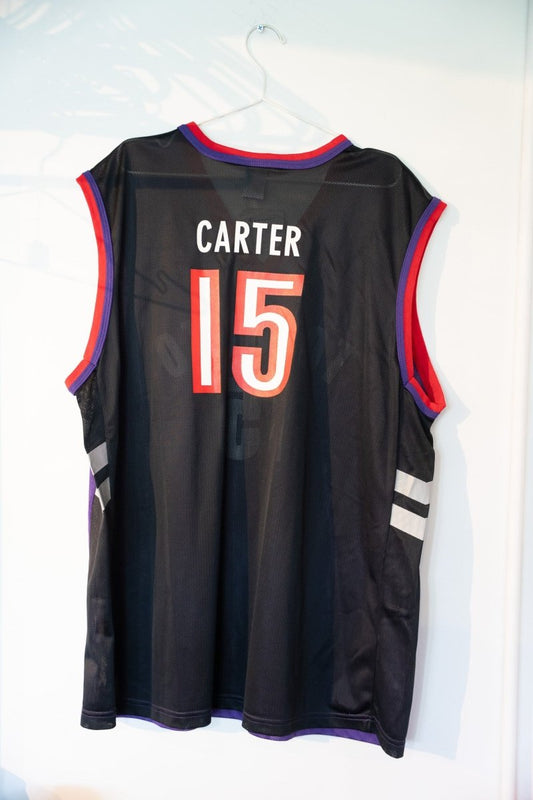 Champion NBA Toronto Raptors basketball jersey in black with red trim, size XL, featuring Vince Carter era design with original retail tags attached