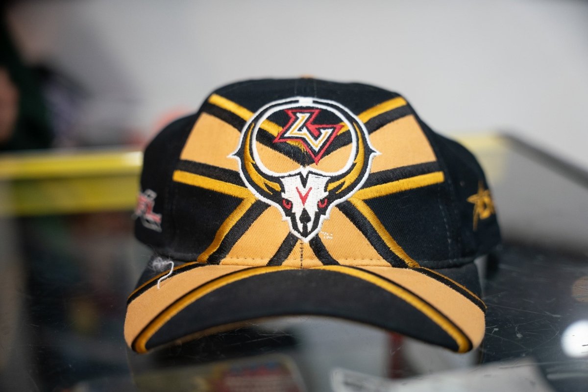 Black and gold vintage Drew Pearson XFL Las Vegas Outlaws hat with white cattle skull red eyes LV logo gold stripe panels and XFL side patch