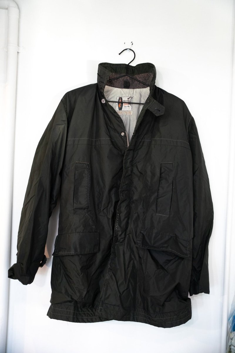 Dark olive green vintage Penneys nylon field jacket with standing collar snap storm flap large flap pockets and gray lining size 40