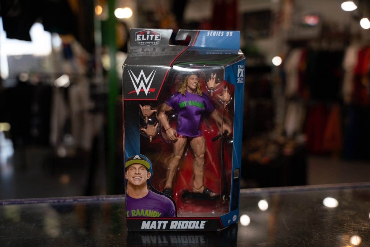 WWE Elite Collection Series 99 Matt Riddle action figure with blonde hair and black wrestling attire, standing posed against white background
