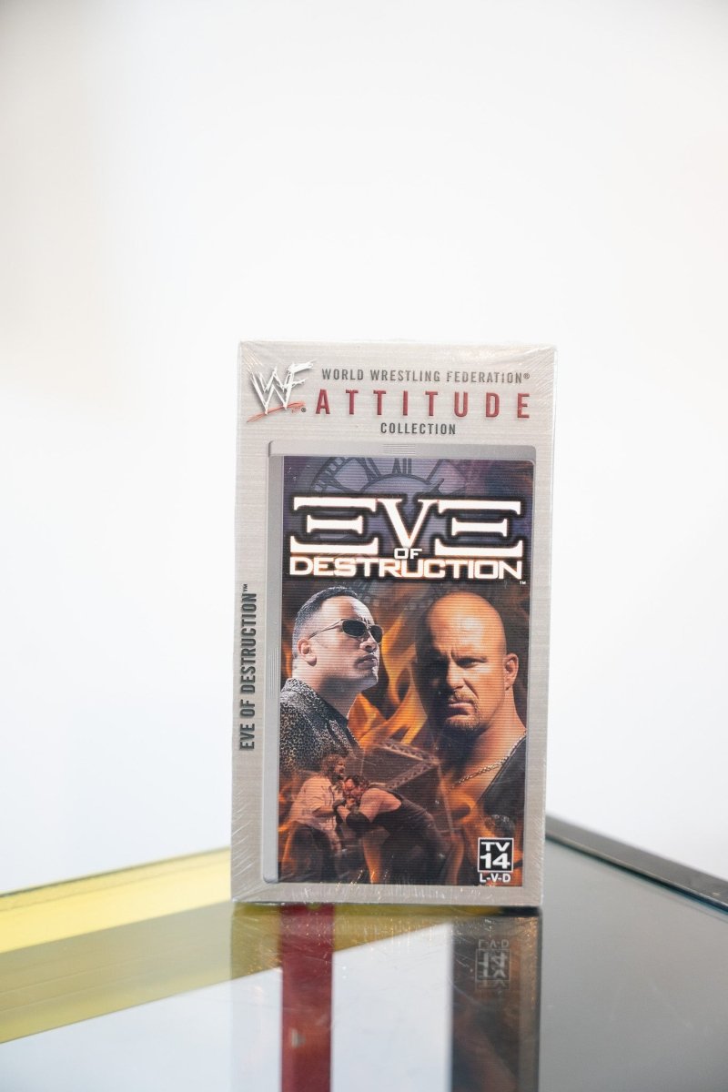 WWF Eve of Destruction VHS tape Attitude Collection The Rock sunglasses Stone Cold Steve Austin fire background angular metallic title text TV-14
