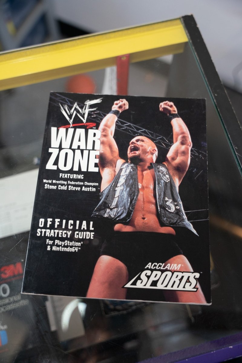 WWF War Zone Official Strategy Guide book Stone Cold Steve Austin fists raised vest PlayStation Nintendo 64 Acclaim Sports dark cover