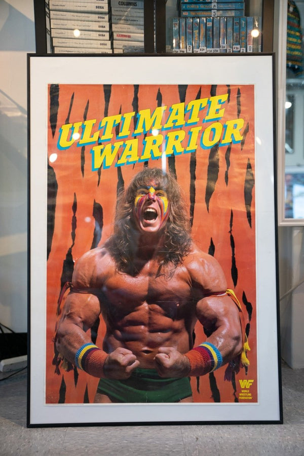 Framed 1989 WWF Titan Sports Ultimate Warrior poster yellow text Warrior flexing face paint tiger stripe background 32x21 inches